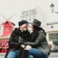 Casal em Paris em frente ao Moulin Rouge durante tour com fotógrafo em Paris