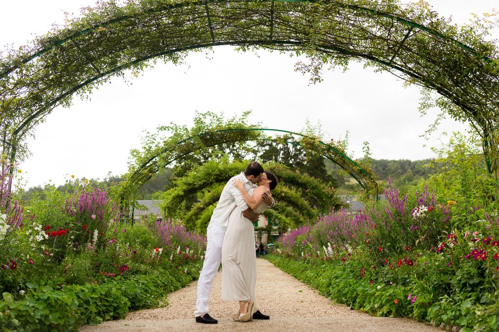 Casal se abraça no Le Clos Normand, caminho central dos Jardins de Monet durante ensaio em Giverny capturado por fotógrafa brasileira em Paris