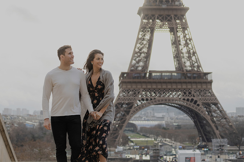Cute couple posing in front of the Eiffel Tower during a romantic photoshoot in Paris